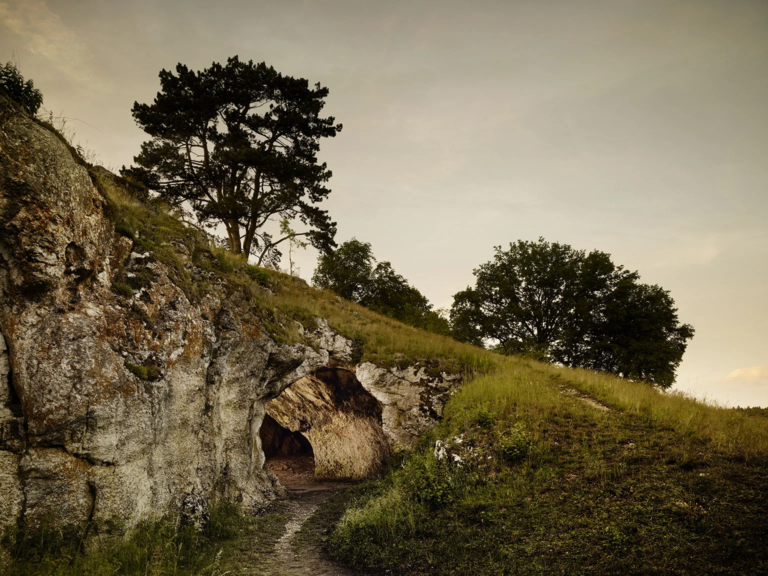 The illuminated entrance to the Vogelherd Cave at dusk