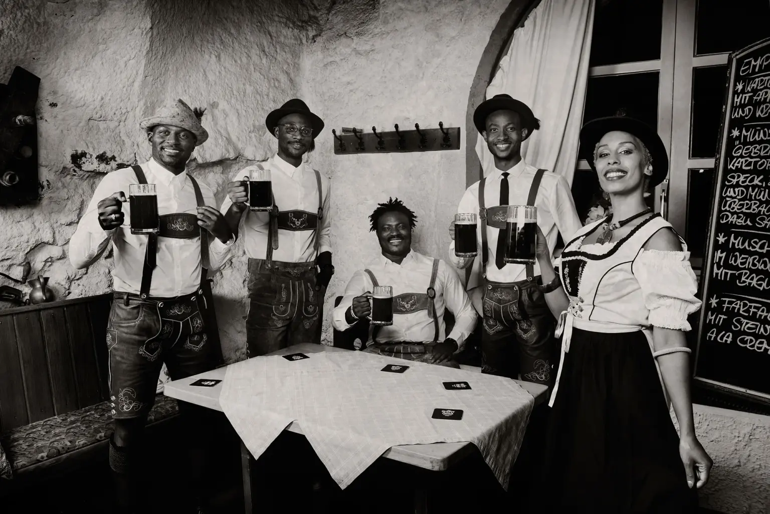 junge schwarze Menschen in bayerischer Tracht in einer deutschen Gasstätte