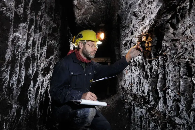 Celtic Salt Mine in Hallstatt, excavation leader Hans Reschreiter examines fir wood chippings in the wall