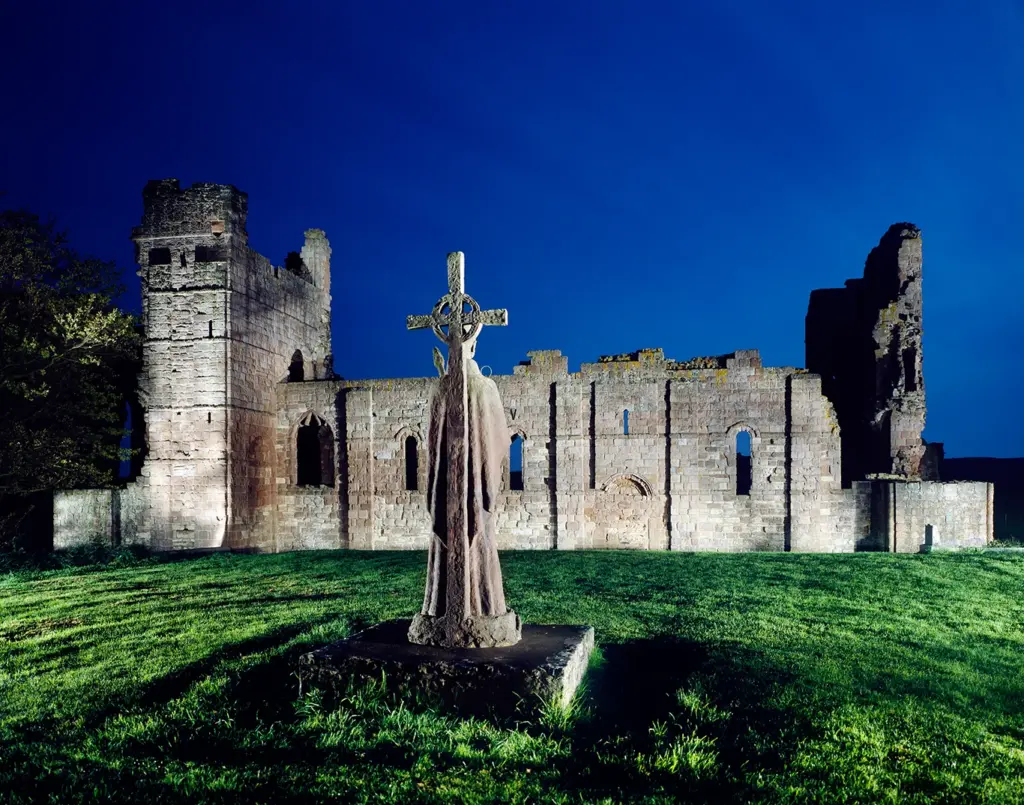 Lindisfarne Priory and St Cuthbert statue